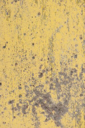 Painted yellow wall cracked paint. The texture of old wall. Background grunge design abstract frame retro house pattern vintage banner constructionの写真素材