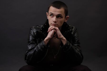Young pensive man on dark background