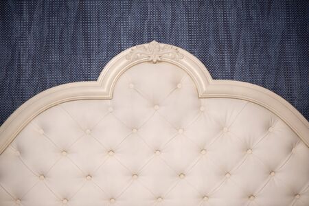 Headboard of a bed in classical style in a bedroom