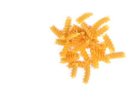 Handful of raw spiral pasta isolated over white backgroundの写真素材