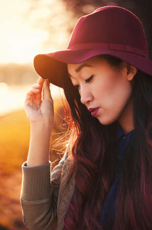 Asian woman in hat outdoors at sunny dayの写真素材