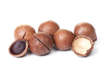 Heap of macadamia nut in shell isolated on white backgroundの写真素材