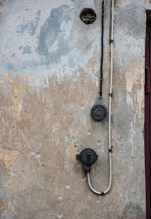 Close-up view of old broken entrance bell with old wires against wallの写真素材