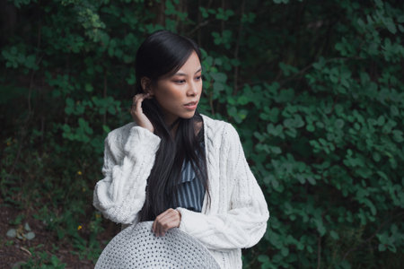 Young pregnant asian woman with white hat outdoorsの写真素材