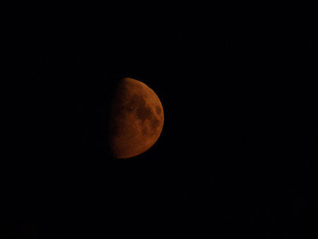 Half of red moon in the night skyの写真素材