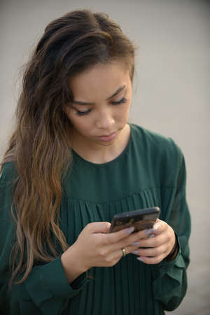 Young woman with mobile phone outdoors