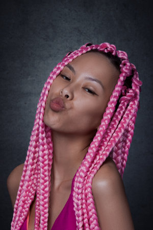Asian joyful woman with long afro braidsの写真素材