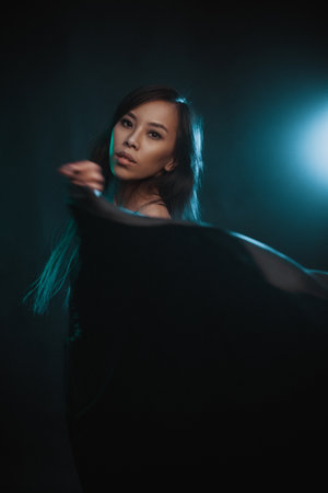 Young asian woman in black dress at motion in studioの写真素材