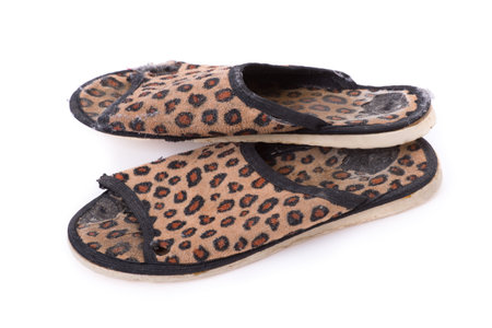 Old worn leopard slippers isolated on white backgroundの写真素材