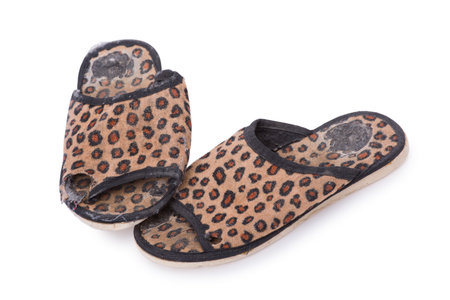 Old worn leopard slippers isolated on white backgroundの写真素材