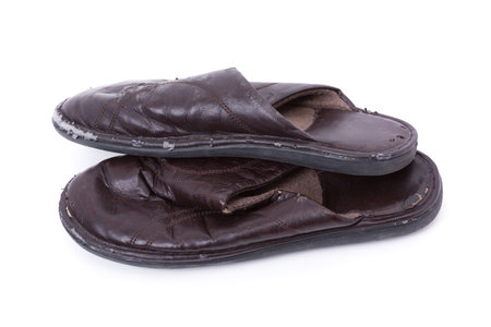 Old worn leather slippers isolated on white backgroundの写真素材