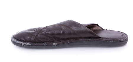 Old worn leather slippers isolated on white backgroundの写真素材