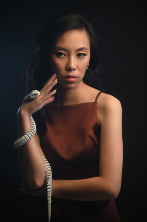 Young asian woman with white artificial snakeの写真素材