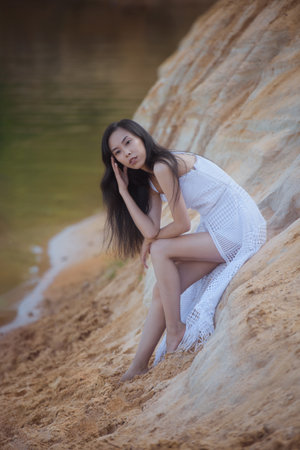 Young asian woman in white dress near water, summer natureの写真素材