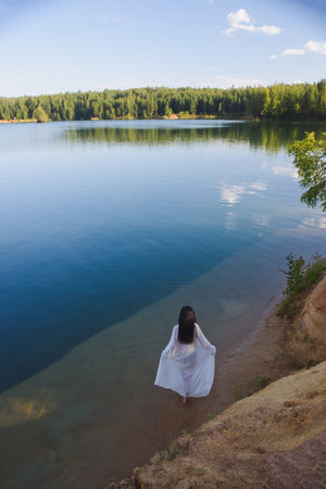 Young asian woman in white dress in pond, summer natureの写真素材