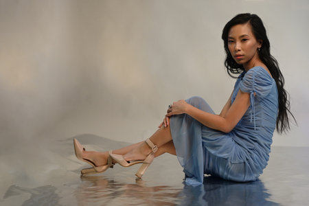 Young asian woman in blue evening dress posing at studioの写真素材
