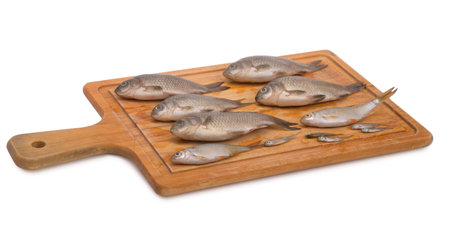 Small fishes on a cutting board isolatedの写真素材