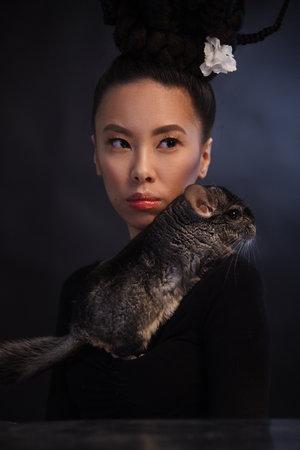 Studio portrait of asian woman with chinchillaの写真素材