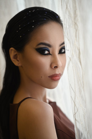Portrait of young asian woman with make-up near windowの写真素材