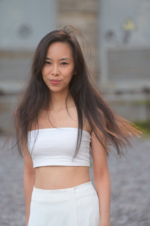 Pretty young asian woman in light clothes outdoorsの写真素材