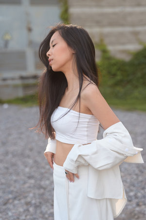 Pretty young asian woman in light clothes outdoorsの写真素材