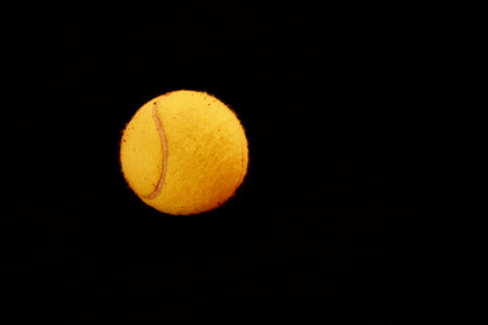 Yellow tennis ball lying on line of the red and green court. flat lay view. Space for textの写真素材