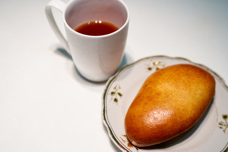 Cup of tea and baked buns on a white background.の写真素材