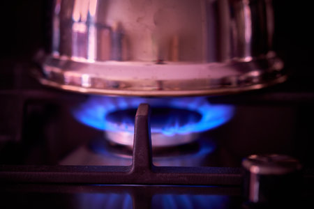Blue flames of a gas stove in the kitchen. Selective focus