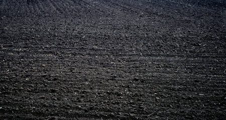 Black plowed field background, close up of plowed field