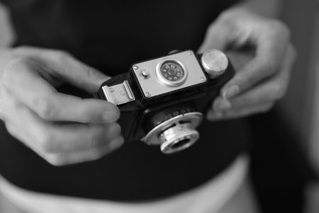 Old camera in the hands of a man. Black and white photo.の写真素材