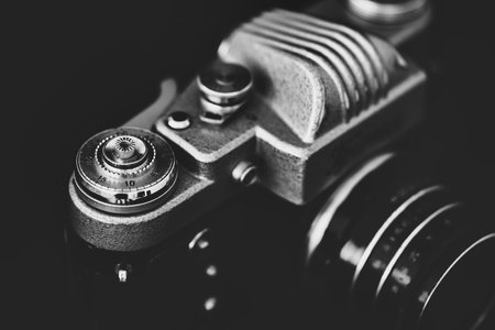 Retro camera on a black background. Black and white photo.
