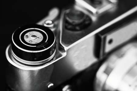 Old camera on a black background close-up. Black and white photo.の写真素材