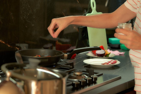 Young woman cooking in the kitchen at home. Selective focus.