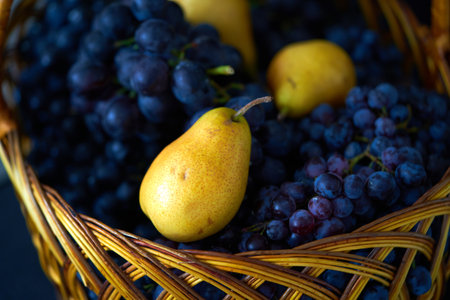 Basket with fresh ripe fruits and grapes. Selective focus.の写真素材