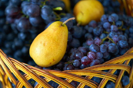 Wicker basket with grapes and pears. Selective focus.の写真素材