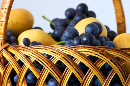 basket of grapes and pears on a white background close upの写真素材