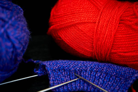 Knitting needles and yarn on a black background. Selective focus.の写真素材
