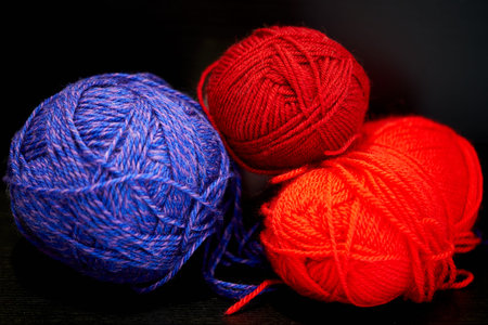 colorful clews for knitting on a black background close-up