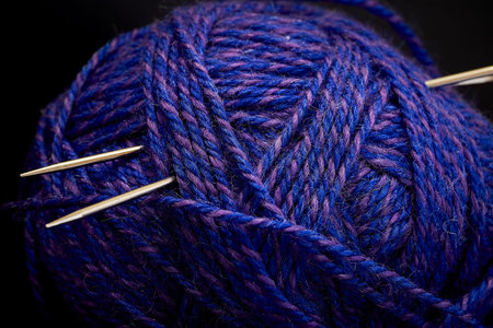 Ball of yarn and knitting needles on a black background close-upの写真素材