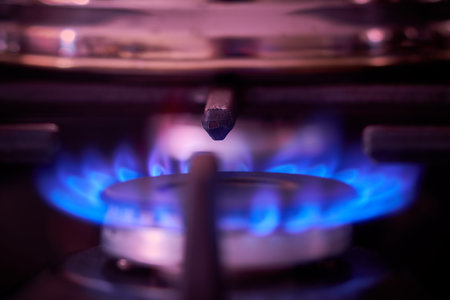 Gas burner with blue flames in the kitchen. Selective focus.