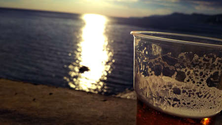 glass of beer against the backdrop of the sea sunset