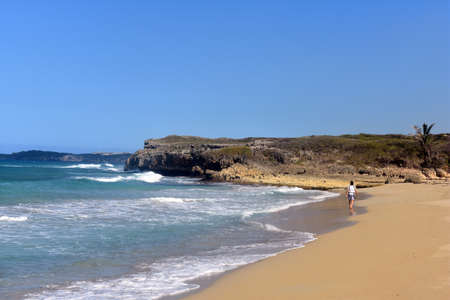 Guy walks on a sandy ocean beachの写真素材