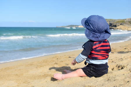 Little boy looks at the oceanの写真素材