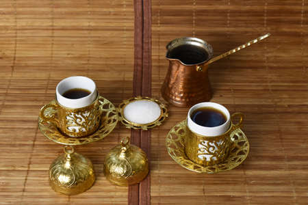 gold cup for coffee on a light backgroundの写真素材