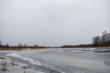 The lake is covered with ice in winterの写真素材