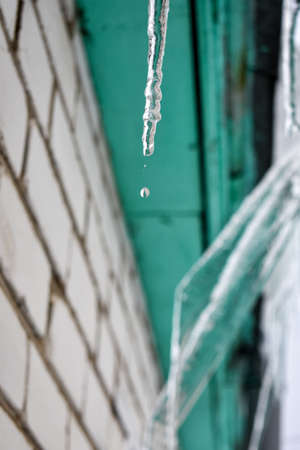 icicles hang from the roof of the houseの写真素材