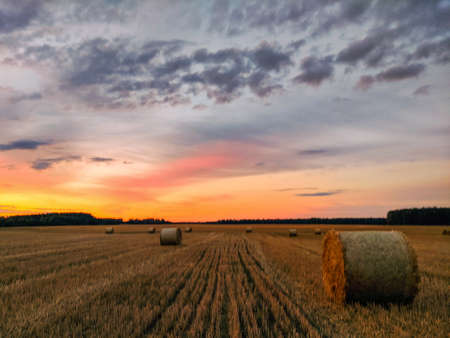 haystacks in a field at sunset