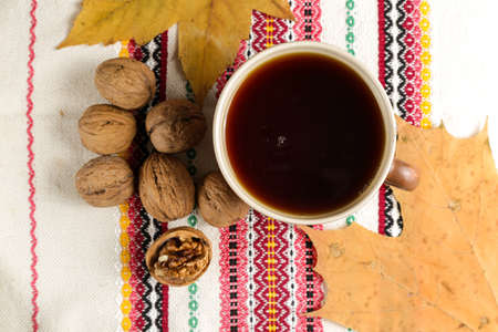 A cup of black tea on a table with a book and a shawlの写真素材