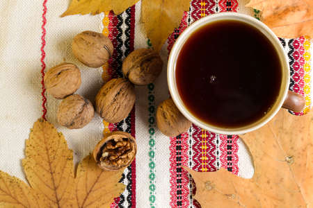 A cup of black tea on a table with a book and a shawlの写真素材