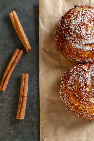 Cinnamon and coconut lemon buns on a pink plate on a gray tableの写真素材